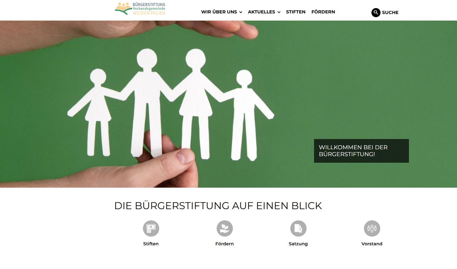 Screenshot Internetseite Bürgerstiftung Zu sehen ist die Startseite der Internetseite mit aus Papier ausgeschnittenen, weißen Personenumrissen vor einem grünen Hintergrund, die von zwei Händen gehalten werden.