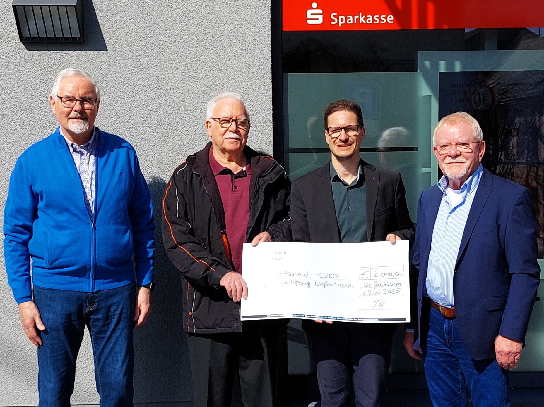 Spendenübergabe Sparkasse Der Vorstand der Bürgerstiftung steht mit dem Weißenthurmer Filialleiter Thorsten Escher vor dem Sparkassengebäude mit einem großen Scheck.